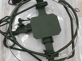 a green device in a plastic case on a white table