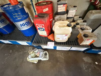 de nombreux bidons d'huile sur une étagère dans un garage