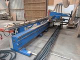 a machine that is cutting a piece of wood in a factory