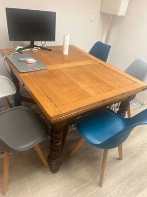 a wooden table with blue chairs and a computer on it