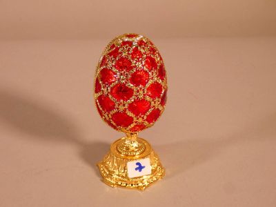 un œuf rouge et doré orné d'une croix