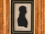 une vieille photo représentant la silhouette d'un homme, dans un cadre en bois