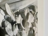a black and white photo of a statue with flowers on it