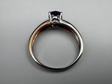 a close up of a ring with a purple stone in it
