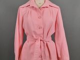 a woman ' s pink shirt with a belt on a mannequin