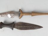 two different types of knives on a white surface