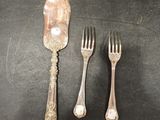 three forks, a spoon and a knife on a table