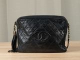 a black chanel bag sitting on top of a wooden table
