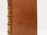 un vieux livre à la couverture brune posé sur une table