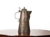 une cafetière en argent posée sur une table en bois, sur fond blanc