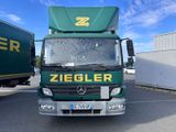 un camion vert garé sur un parking