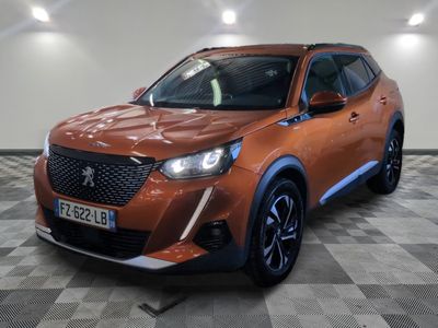 la voiture orange est garée dans le garage sur un sol en damier