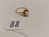 une bague ornée d'une perle et d'une étiquette de prix
