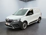 La camionnette blanche est garée dans une grande pièce au sol noir.
