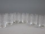 six verres à pied en verre transparent alignés en cercle sur une table