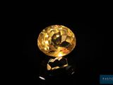 un diamant jaune sur une surface noire