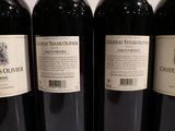 three bottles of red wine are lined up on a table