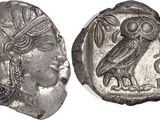 a silver coin with an image of a woman and an owl on it