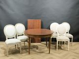 four white chairs around a round table with a wooden top