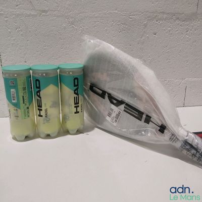 quatre raquettes de tennis emballées dans des sacs en plastique, posées sur une table