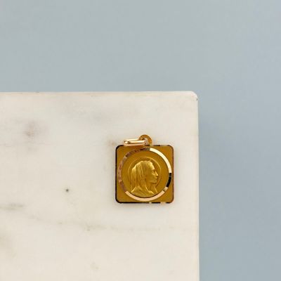 une médaille d'or posée sur un bloc de marbre blanc