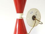 une lampe rouge posée sur une table blanche