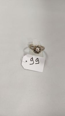 gros plan d'une bague sur une surface blanche avec une étiquette de prix