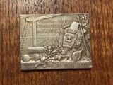 a close up of a metal plaque on a wooden surface