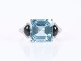 a close up of a ring with a blue topaz and black onyx