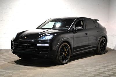 une photo d'une Porsche Cayenne noire garée dans un garage