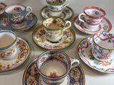 many cups and saucers sitting on a table