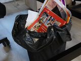 a black trash bag sitting on the floor next to a chair