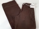 Le pantalon est marron et porte une étiquette blanche.