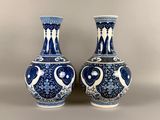 two blue and white vases sitting next to each other