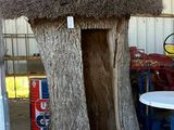 une petite cabane faite d'un tronc d'arbre et recouverte d'un toit de chaume