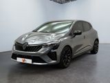 Une voiture grise est garée dans une grande pièce équipée d'un ventilateur de plafond.