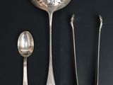 une cuillère, une cuillère et un repose-cuillère posés sur une surface noire