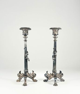 pair of silver candlesticks with figures on the sides