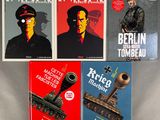three books on a table with a picture of a soldier and a tank