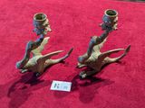 two candles that are sitting on a red carpet