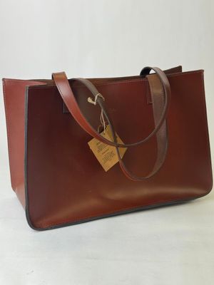 a brown leather bag with a tag on it