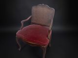 une vieille chaise avec un coussin rouge et un dossier en osier