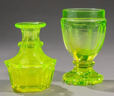 two green glass vases sitting next to each other on a table