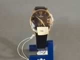 une montre posée sur un présentoir, accompagnée d'une étiquette