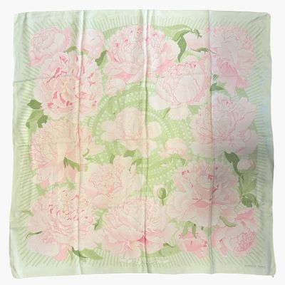 un gros plan d'un foulard à motifs floraux roses et verts sur fond blanc