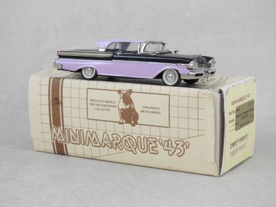 une maquette de voiture violette et noire posée sur une boîte en carton