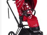 the stroller is red and white with polka dots on it