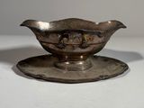 a silver plate with a saucer on it on a white surface