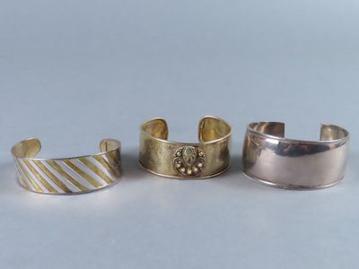trois bracelets manchette en argent et en or