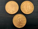 trois pièces d'or posées sur une table en bois